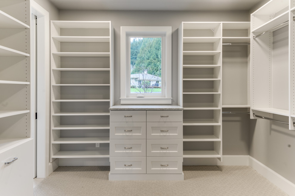 Mid-sized transitional gender-neutral dressing room in Portland with shaker cabinets, white cabinets, carpet and grey floor.