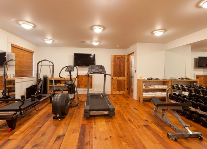 Inspiration for a mid-sized rustic medium tone wood floor and brown floor multiuse home gym remodel in Denver with beige walls