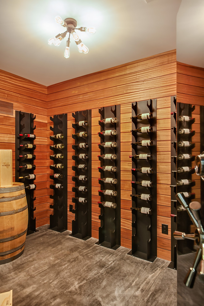 Photo of a contemporary wine cellar in Seattle with concrete floors, display racks and grey floor.
