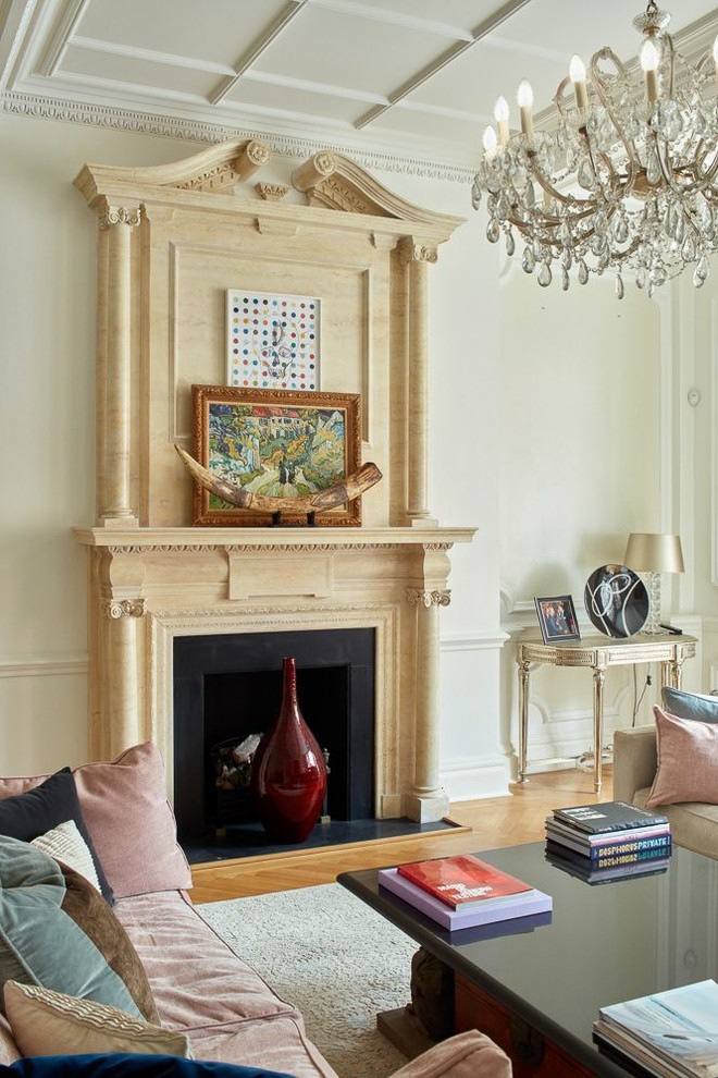 This is an example of a mid-sized traditional enclosed living room in London with white walls, medium hardwood floors, a standard fireplace, a stone fireplace surround and brown floor.