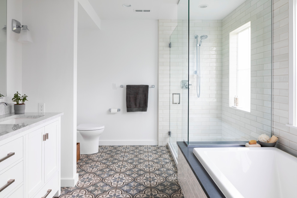 Photo of a mid-sized contemporary master bathroom in Seattle with beaded inset cabinets, white cabinets, an alcove tub, an alcove shower, a one-piece toilet, white tile, subway tile, white walls, porcelain floors, an undermount sink, marble benchtops, blue floor, a hinged shower door, grey benchtops, a shower seat, a double vanity and a built-in vanity.