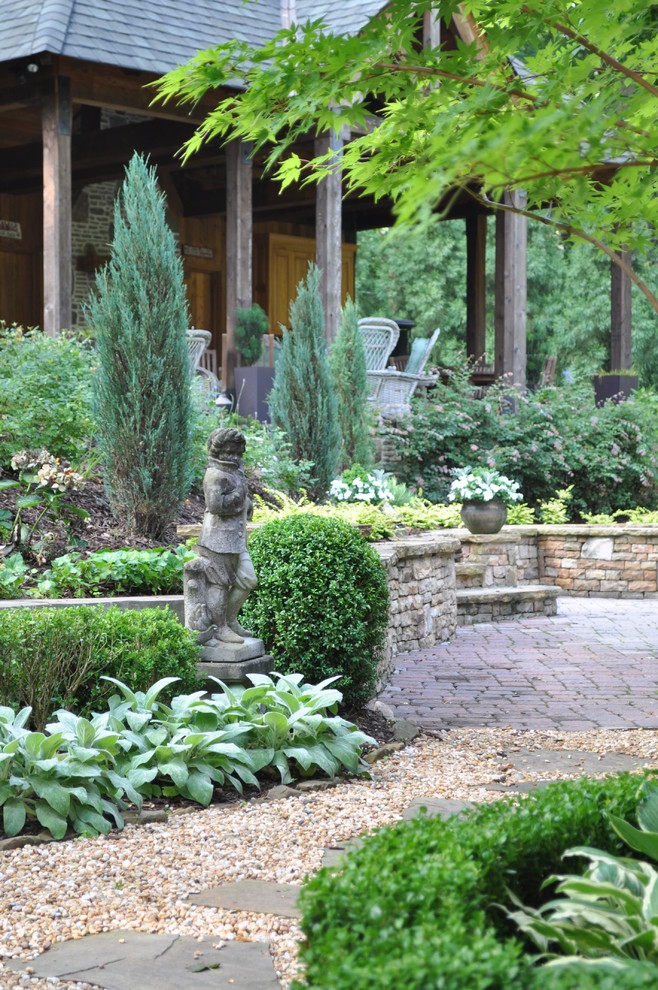 This is an example of a traditional backyard garden in Atlanta with natural stone pavers.