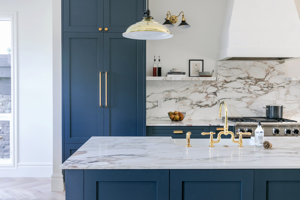 Mid-sized transitional galley light wood floor open concept kitchen photo in Calgary with a double-bowl sink, shaker cabinets, blue cabinets, marble countertops, multicolored backsplash, marble backsplash, paneled appliances, an island and multicolored countertops