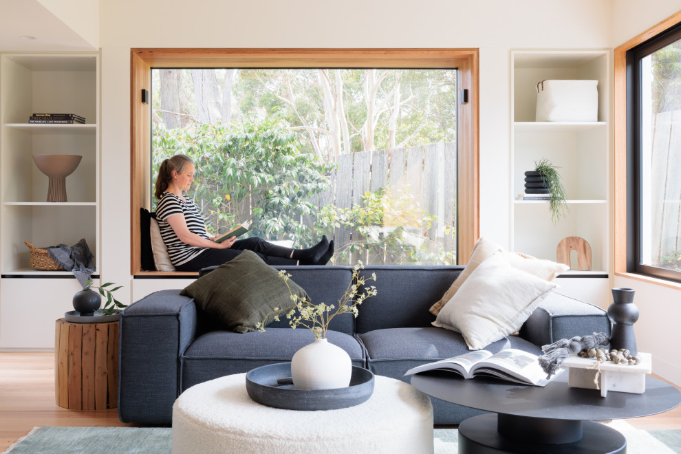 Свежая идея для дизайна: гостиная комната в морском стиле с синим диваном - отличное фото интерьера