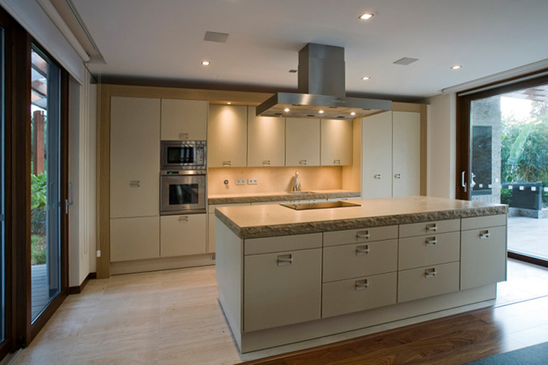 Mid-sized transitional single-wall travertine floor eat-in kitchen photo with an undermount sink, flat-panel cabinets, white cabinets, marble countertops, stainless steel appliances and an island