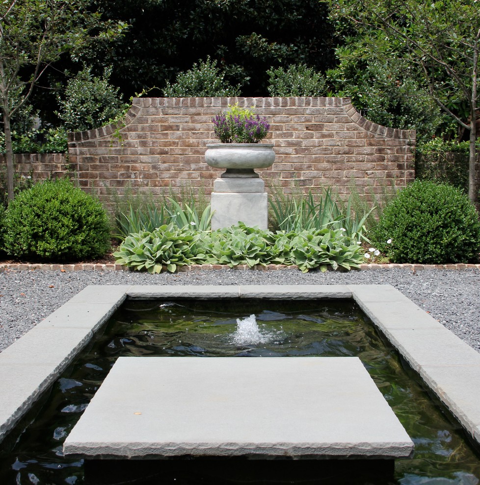 Design ideas for a mid-sized traditional side yard garden in Charlotte with a water feature and gravel.