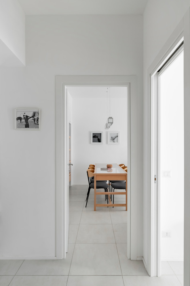 Imagen de comedor actual de tamaño medio con paredes blancas, suelo de baldosas de porcelana y suelo beige