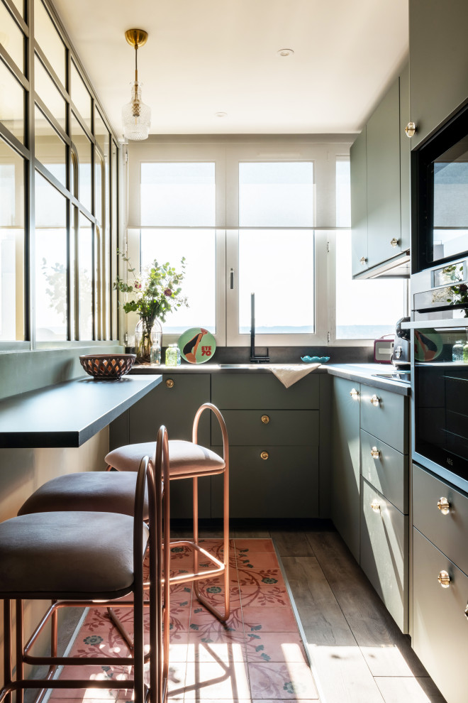 Design ideas for a small contemporary l-shaped separate kitchen in Paris with an integrated sink, beaded inset cabinets, green cabinets, laminate benchtops, pink splashback, ceramic splashback, panelled appliances, cement tiles, pink floor and grey benchtop.