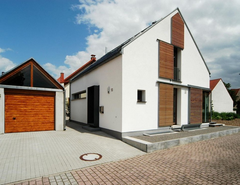 This is an example of a mid-sized contemporary three-storey white exterior in Berlin with a gable roof.