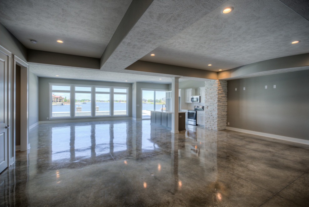 Design ideas for a large modern walk-out basement in Omaha with concrete floors.