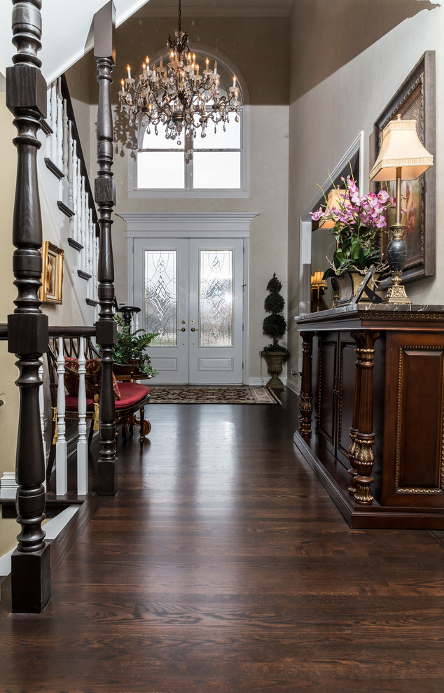 This is an example of a large arts and crafts hallway in Chicago with beige walls, dark hardwood floors and brown floor.
