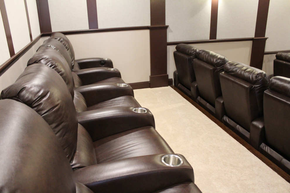 This is an example of an expansive traditional enclosed home theatre in Other with beige walls, carpet, a projector screen and beige floor.