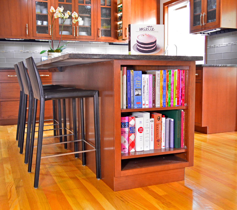 Open concept kitchen - large transitional medium tone wood floor open concept kitchen idea in Seattle with an undermount sink, flat-panel cabinets, dark wood cabinets, quartz countertops, gray backsplash, subway tile backsplash, stainless steel appliances and an island