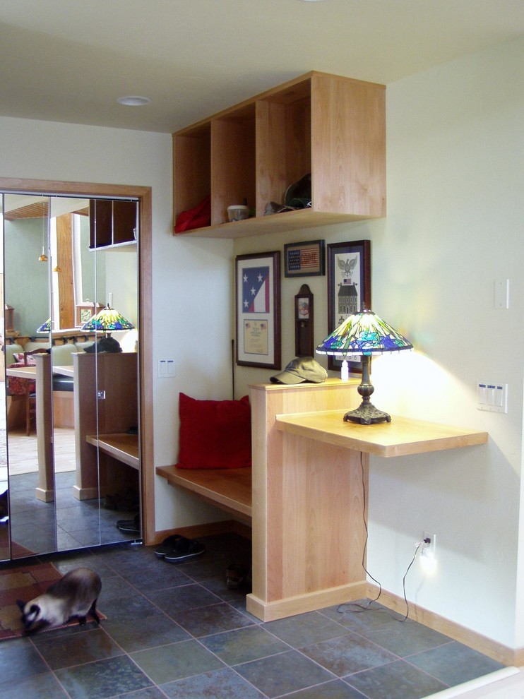 Example of a small slate floor and gray floor foyer design with white walls