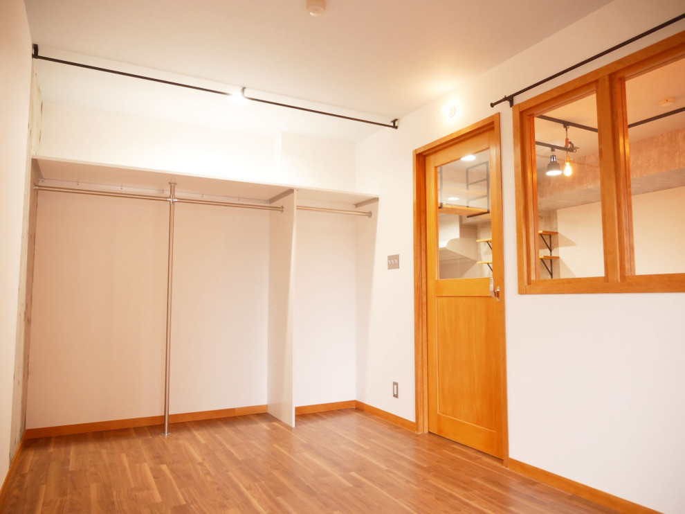 Bild på ett litet 60 tals huvudsovrum, med vita väggar, vinylgolv och brunt golv