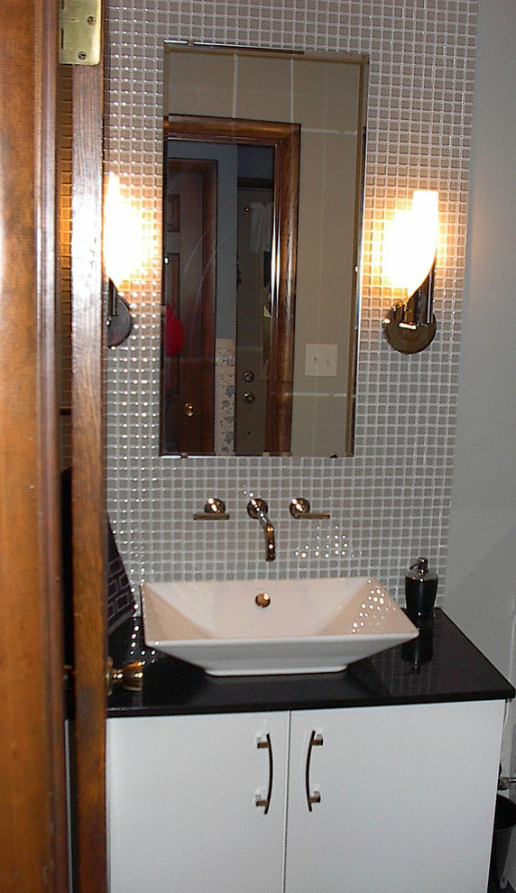 Example of a small trendy gray tile and glass tile home design design with flat-panel cabinets, white cabinets, gray walls, a vessel sink and quartzite countertops
