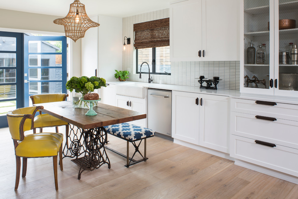 This is an example of a contemporary kitchen in Other with a farmhouse sink, shaker cabinets, white cabinets, matchstick tile splashback and light hardwood floors.