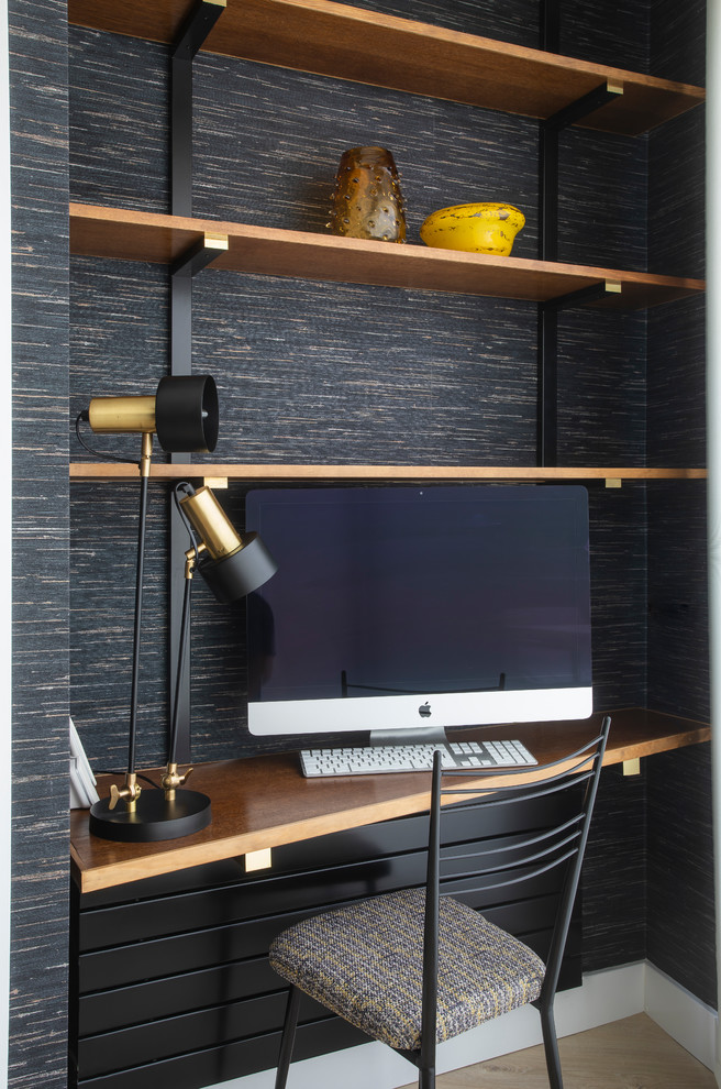 Inspiration for a small contemporary study room in Other with black walls, a built-in desk and light hardwood floors.