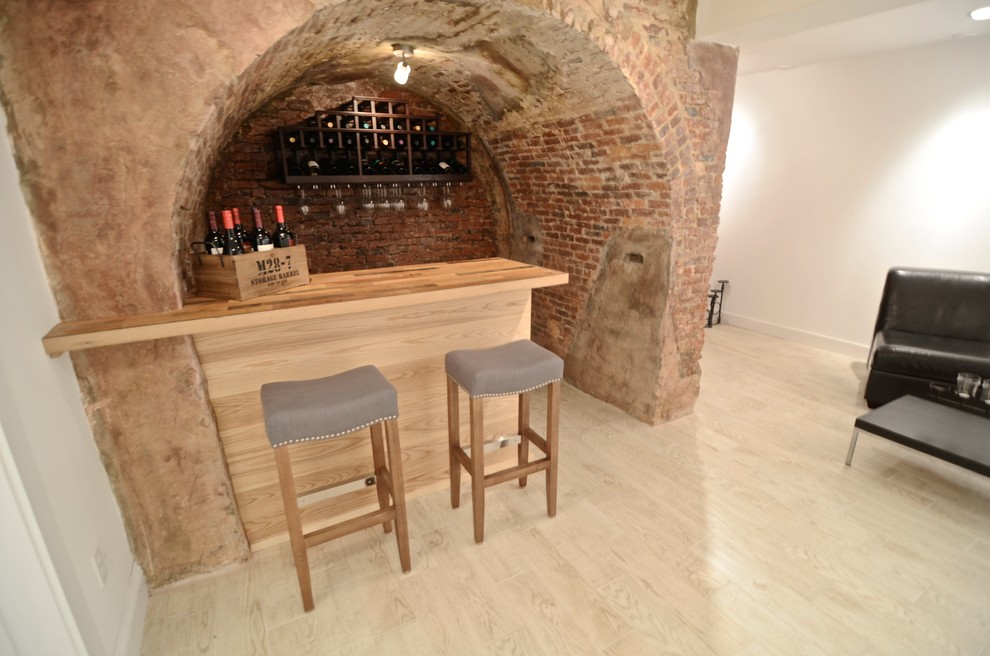 This is an example of a small country single-wall seated home bar in Boston with wood benchtops, red splashback, brick splashback, light hardwood floors, beige floor and beige benchtop.
