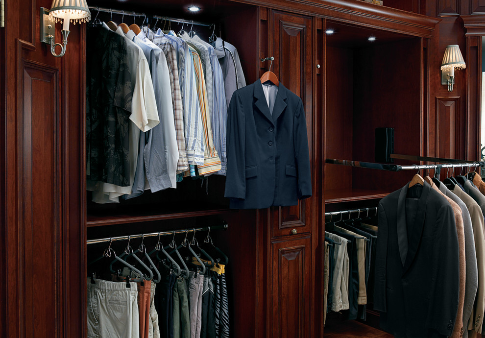 Large traditional gender-neutral walk-in wardrobe in Houston with raised-panel cabinets, dark wood cabinets, light hardwood floors and yellow floor.