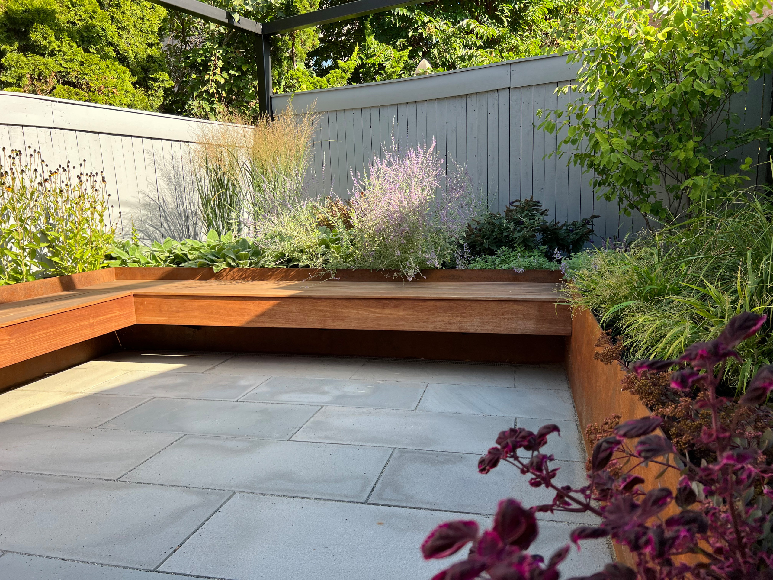 Paved patio with metal grating garden