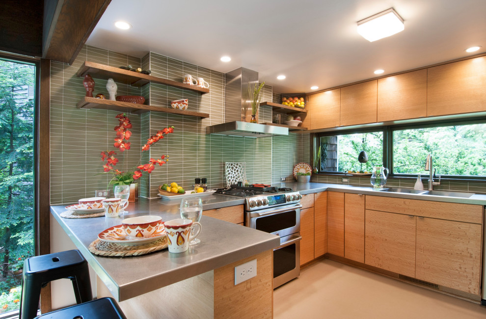 Inspiration for a midcentury u-shaped kitchen in Columbus with a double-bowl sink, flat-panel cabinets, light wood cabinets, green splashback, mosaic tile splashback, stainless steel appliances, a peninsula, beige floor and grey benchtop.