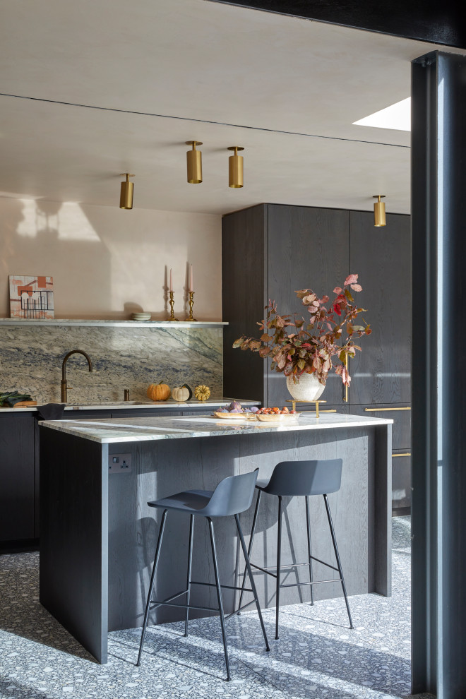 Large modern l-shaped eat-in kitchen in London with an integrated sink, flat-panel cabinets, black cabinets, marble benchtops, multi-coloured splashback, stone slab splashback, terrazzo floors, with island, grey floor and multi-coloured benchtop.