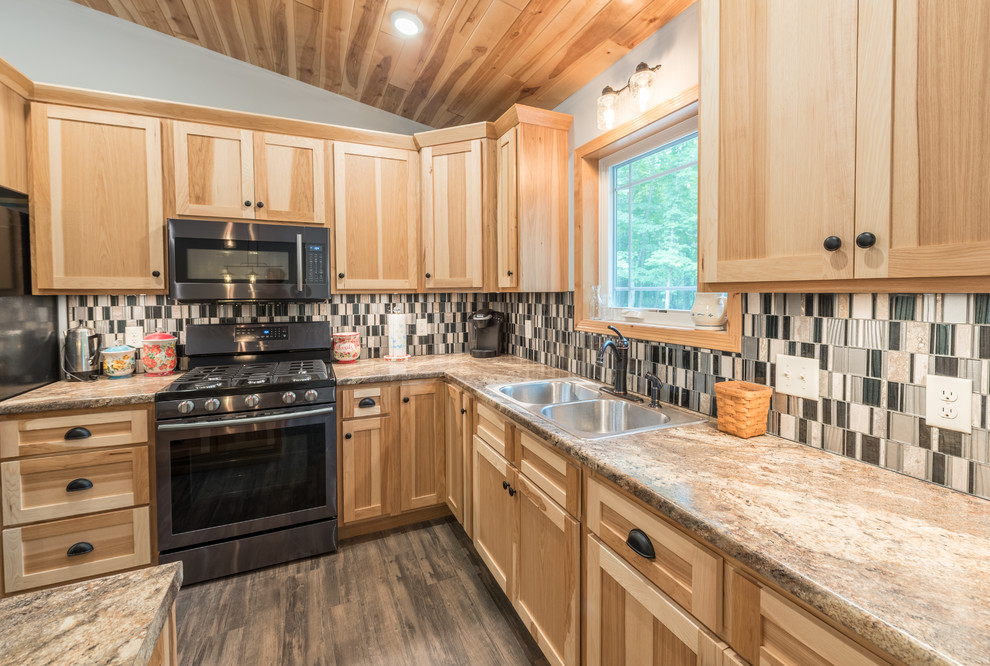 Photo of a mid-sized country l-shaped eat-in kitchen in Minneapolis with a drop-in sink, shaker cabinets, light wood cabinets, granite benchtops, multi-coloured splashback, glass tile splashback, stainless steel appliances, vinyl floors, with island, brown floor and multi-coloured benchtop.