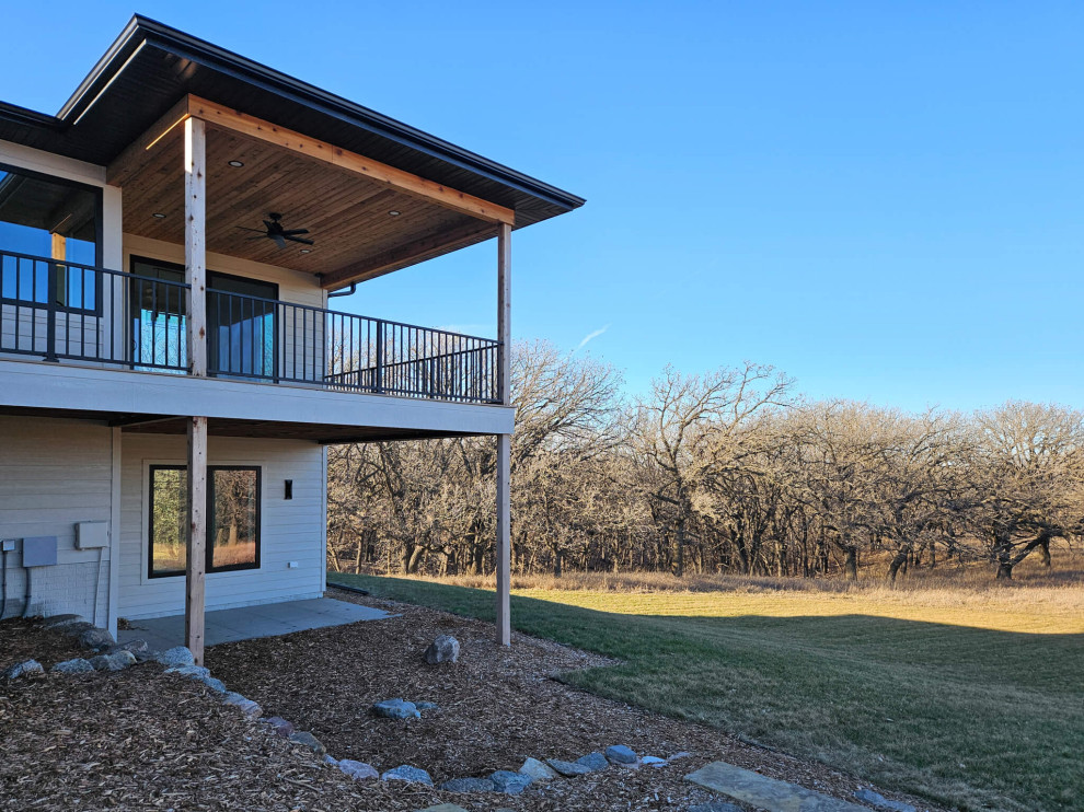 Inspiration for a large backyard second story metal railing deck remodel with a roof extension