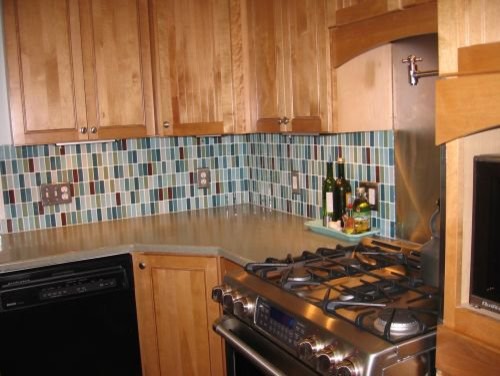 Open concept kitchen - large transitional u-shaped open concept kitchen idea in New York with recessed-panel cabinets, light wood cabinets, multicolored backsplash, glass tile backsplash and stainless steel appliances