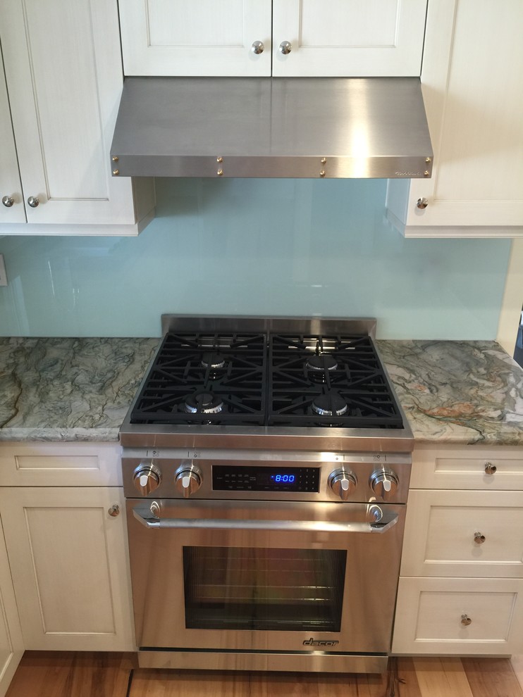 Mid-sized eclectic light wood floor kitchen photo in Calgary with shaker cabinets, white cabinets, quartzite countertops, stainless steel appliances, an island and glass sheet backsplash