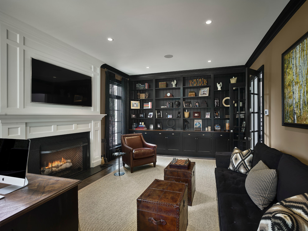 Design ideas for a mid-sized transitional home office in Philadelphia with a library, beige walls, carpet, a standard fireplace, a stone fireplace surround and a freestanding desk.