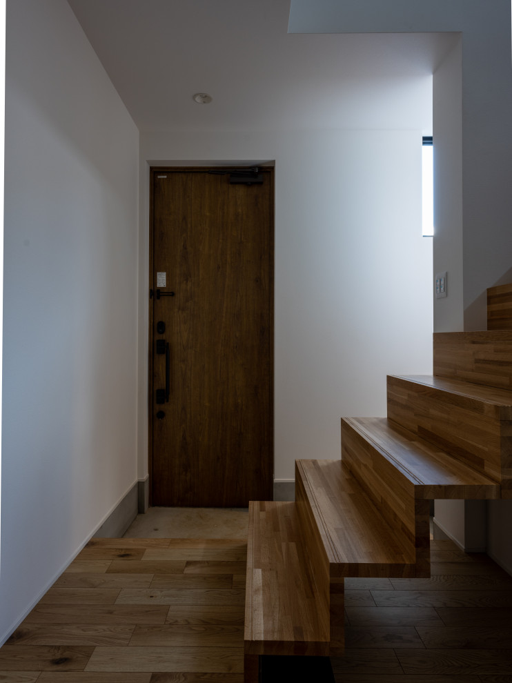Kleine Skandinavische Haustür mit weißer Wandfarbe, Einzeltür, dunkler Holzhaustür, Tapetendecke, Tapetenwänden und grauem Boden in Sonstige