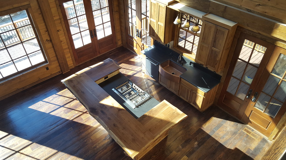 Inspiration for a mid-sized rustic dark wood floor kitchen remodel in Atlanta with a farmhouse sink, shaker cabinets, medium tone wood cabinets, granite countertops, beige backsplash, ceramic backsplash, stainless steel appliances and an island