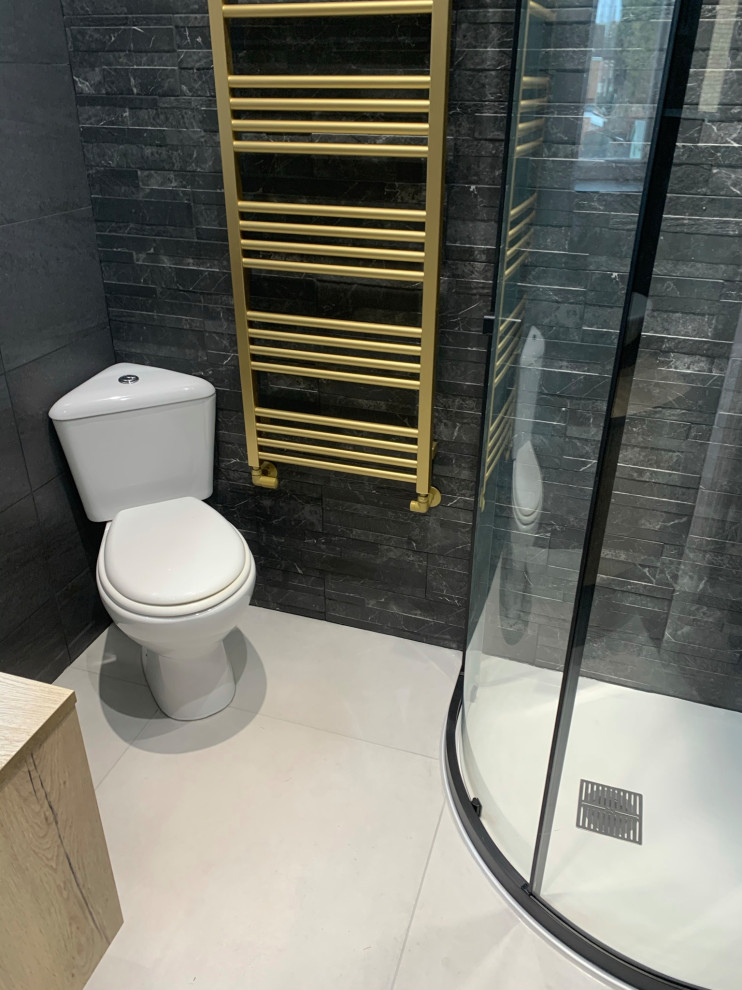 Design ideas for a small modern master bathroom in Cambridgeshire with flat-panel cabinets, light wood cabinets, a corner shower, a two-piece toilet, black tile, a vessel sink, laminate benchtops, a sliding shower screen, a single vanity and a floating vanity.