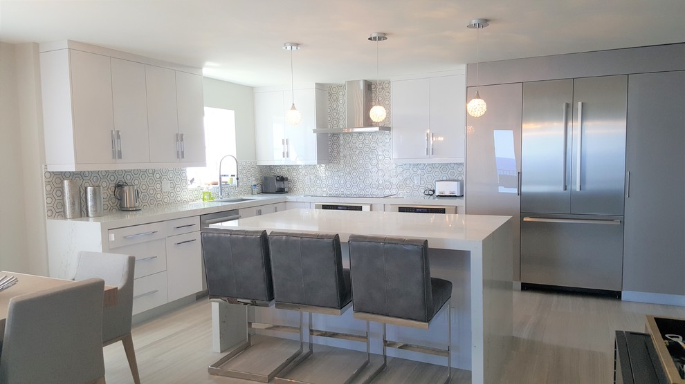 Small modern l-shaped open plan kitchen in Miami with an undermount sink, flat-panel cabinets, white cabinets, quartz benchtops, multi-coloured splashback, ceramic splashback, stainless steel appliances, marble floors, with island and grey floor.