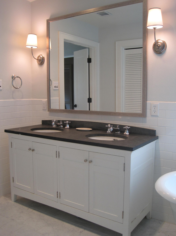 This is an example of a mid-sized traditional master bathroom in Austin with furniture-like cabinets, white cabinets, a freestanding tub, a two-piece toilet, white tile, subway tile, white walls, an undermount sink and granite benchtops.