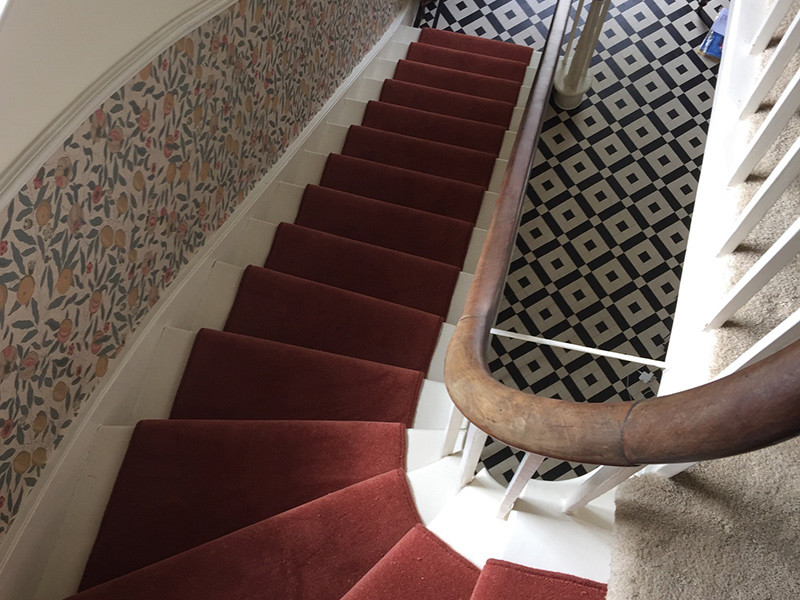 Photo of a mid-sized traditional carpeted curved staircase in London with carpet risers and mixed railing.