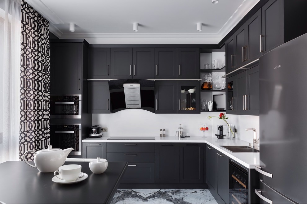 Mid-sized transitional l-shaped separate kitchen in Saint Petersburg with a double-bowl sink, shaker cabinets, black appliances, marble floors, no island, quartz benchtops, grey splashback and white benchtop.
