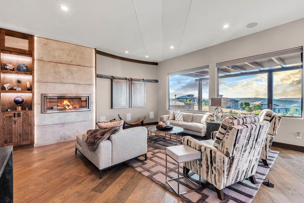 Small modern open concept living room in Denver with grey walls, a standard fireplace, a concrete fireplace surround and multi-coloured floor.