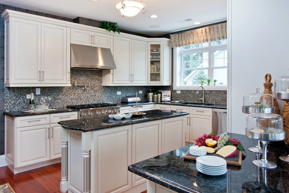 Large transitional l-shaped dark wood floor eat-in kitchen photo in Chicago with an undermount sink, raised-panel cabinets, white cabinets, granite countertops, multicolored backsplash, mosaic tile backsplash, stainless steel appliances and an island