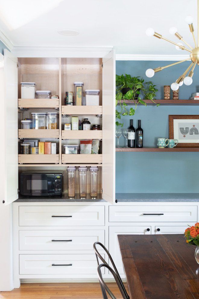 Mid-sized transitional u-shaped light wood floor and brown floor eat-in kitchen photo in Austin with an undermount sink, shaker cabinets, white cabinets, quartz countertops, blue backsplash, glass tile backsplash, stainless steel appliances, no island and gray countertops