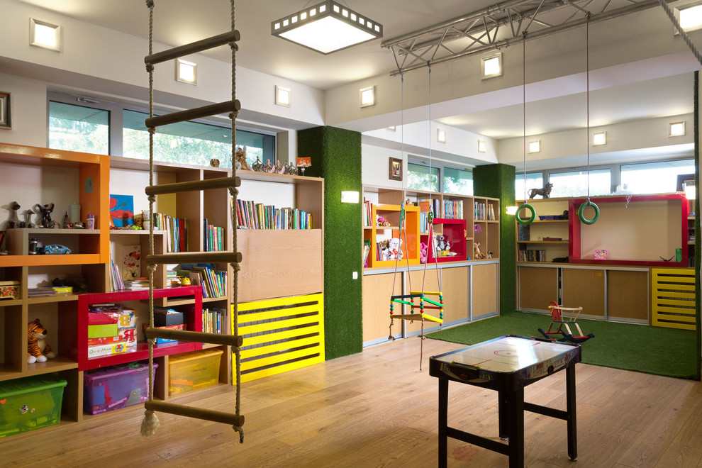 Eclectic gender-neutral kids' room in Other with white walls and light hardwood floors.