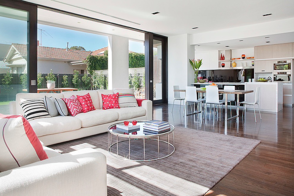 Photo of a contemporary open concept living room in Melbourne with white walls and medium hardwood floors.