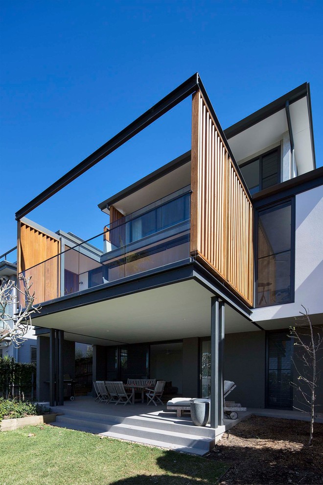 This is an example of a large contemporary three-storey grey house exterior in Sydney with concrete fiberboard siding, a flat roof and a metal roof.