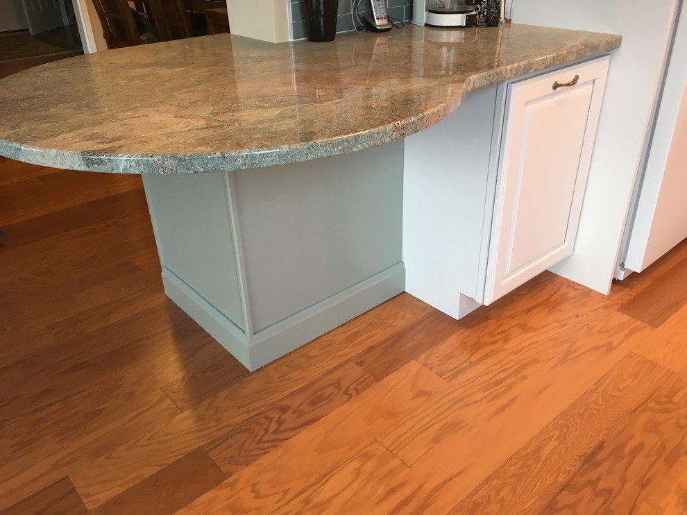 Kitchen - transitional u-shaped medium tone wood floor kitchen idea in Boston with a drop-in sink, raised-panel cabinets, white cabinets, granite countertops, green backsplash, glass tile backsplash, white appliances, a peninsula and green countertops