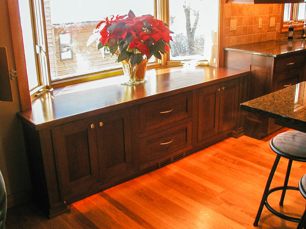 Inspiration for a mid-sized l-shaped eat-in kitchen remodel with an undermount sink, shaker cabinets, dark wood cabinets, granite countertops, stainless steel appliances and an island
