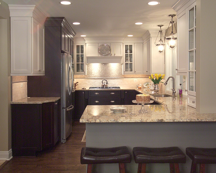 Eat-in kitchen - transitional u-shaped eat-in kitchen idea in Chicago with an undermount sink, flat-panel cabinets, granite countertops, beige backsplash, stone tile backsplash and stainless steel appliances