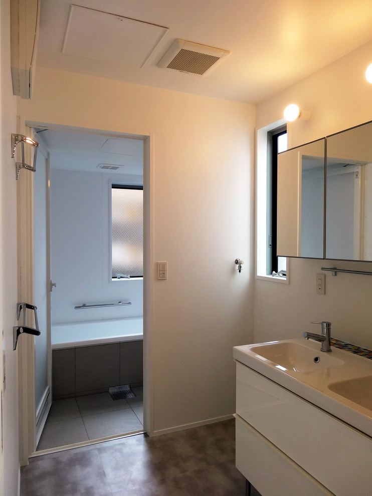 Photo of a mid-sized modern master wet room bathroom in Tokyo with flat-panel cabinets, white cabinets, a corner tub, white tile, porcelain tile, white walls, porcelain floors, an integrated sink, brown floor and white benchtops.