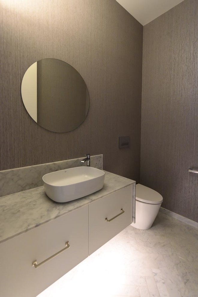 This is an example of a mid-sized modern bathroom in Melbourne with flat-panel cabinets, white cabinets, a one-piece toilet, brown walls, marble floors, a vessel sink, marble benchtops, multi-coloured floor and multi-coloured benchtops.
